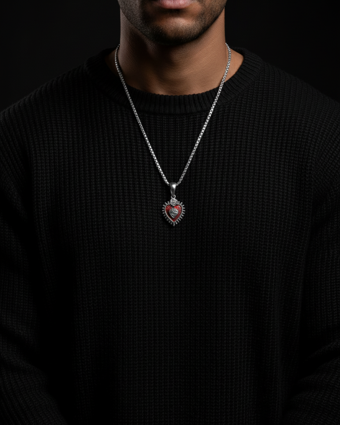 Man wearing a black sweater with a silver necklace featuring a Illuminati Heart Pendant