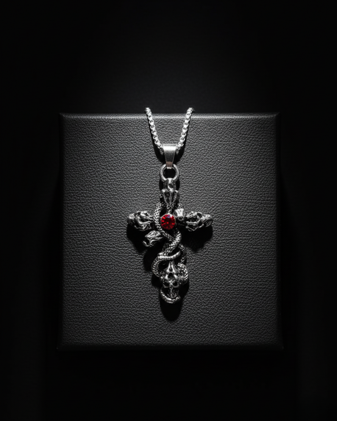 Skull Cross Pendant with a red gemstone on a dark background