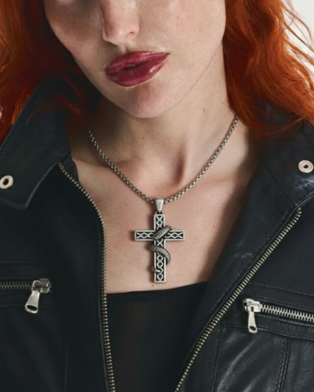 Person wearing a black leather jacket with a necklace featuring a Veritas Serpent Pendant