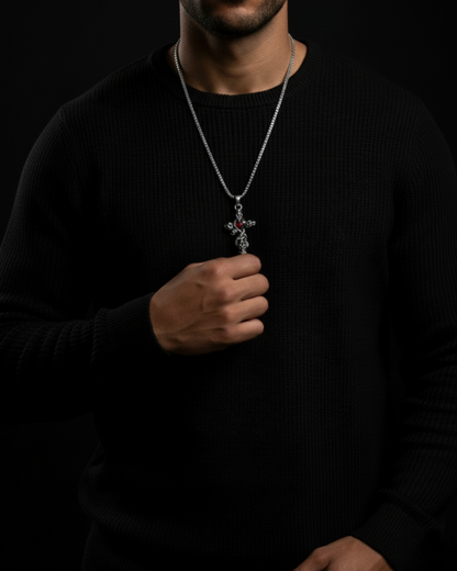 Person wearing a black sweater with a necklace featuring a Skull Cross Pendant on a dark background